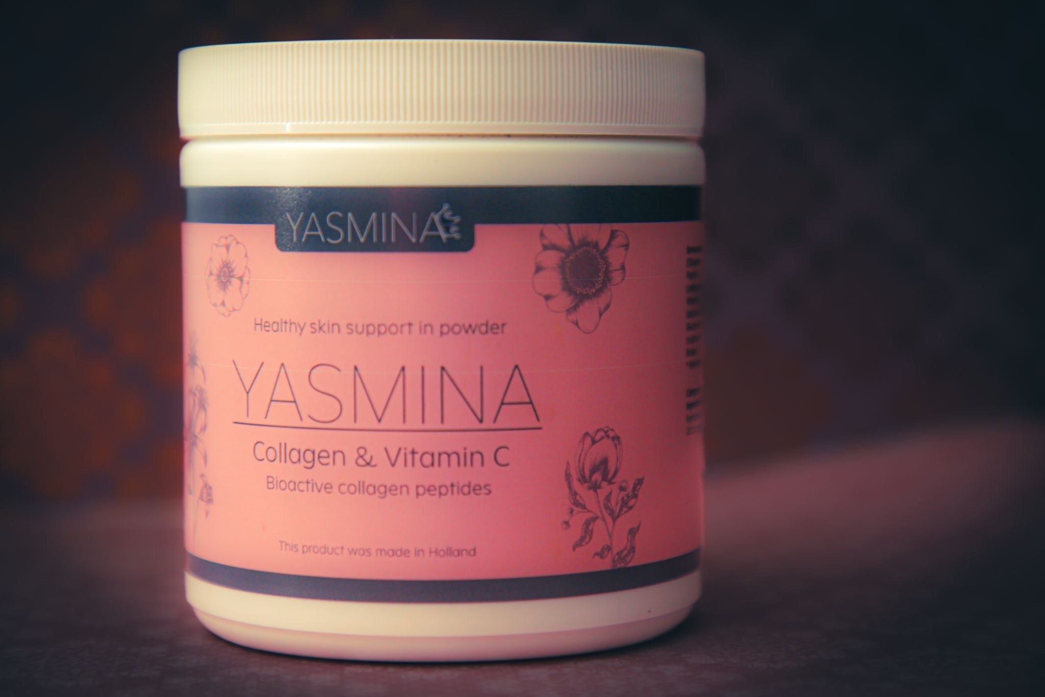 Ein rosafarbenes Behälter mit dem Produkt Yasmina, Kollagen und Vitamin C, mit floralen Motiven.