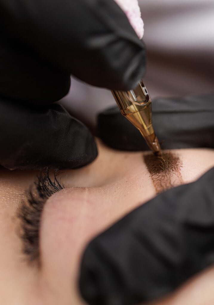 Macro photo introduction of pigment into the skin with a tattoo machine eyebrow correction. Second PMU procedure in a month of permanent eyebrow makeup. Permanent makeup correction.